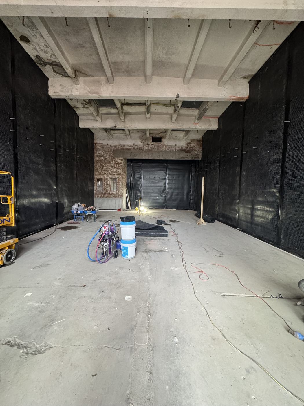 Newton cavity drain membrane installed floor to ceiling across the walls, slab dry